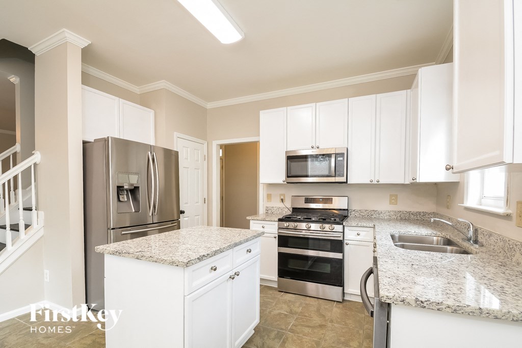 A kitchen with granite countertops and stainless steel appliances.