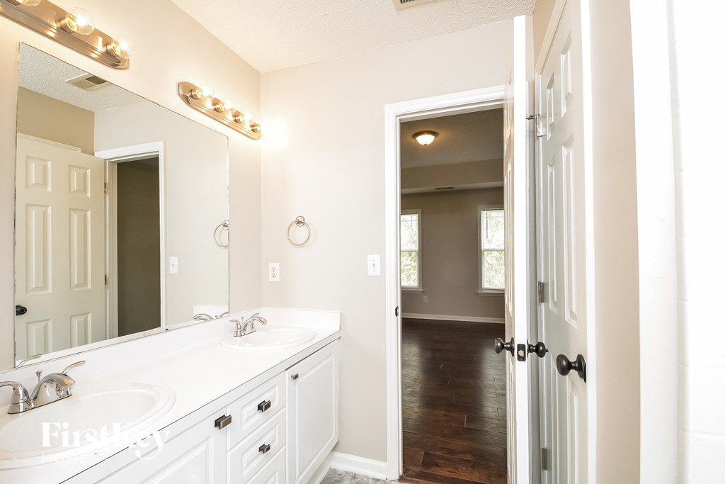 A bathroom with a white sink and a mirror above it.