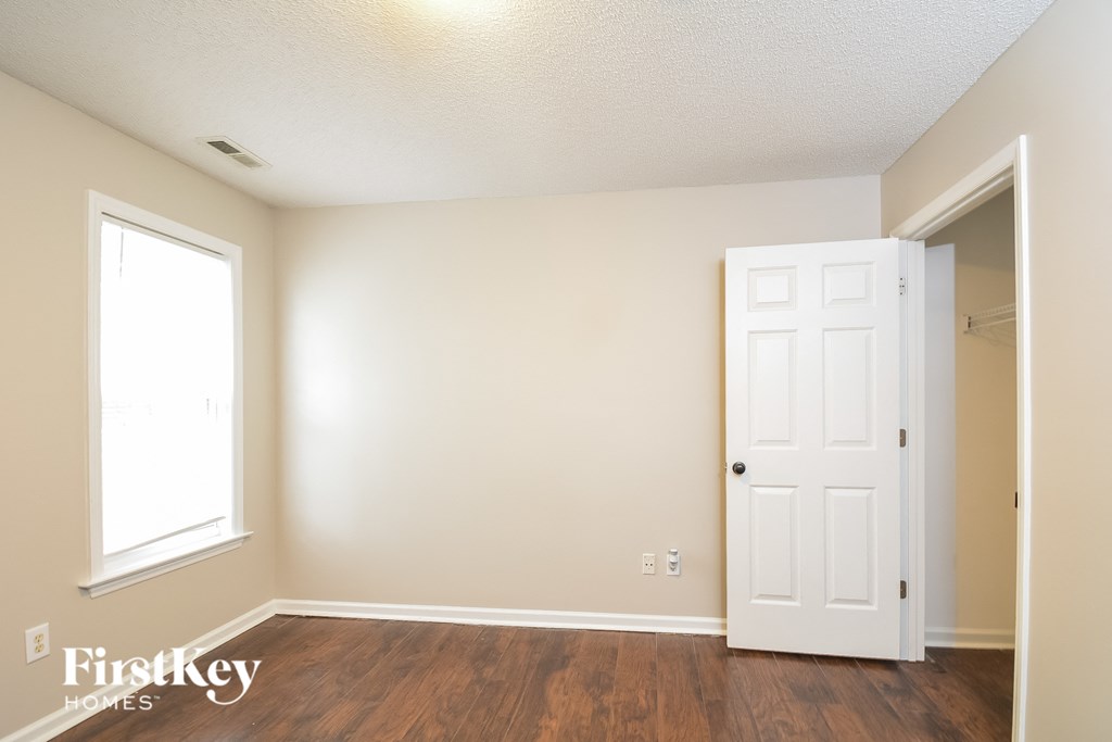 A room with a white door and a window.
