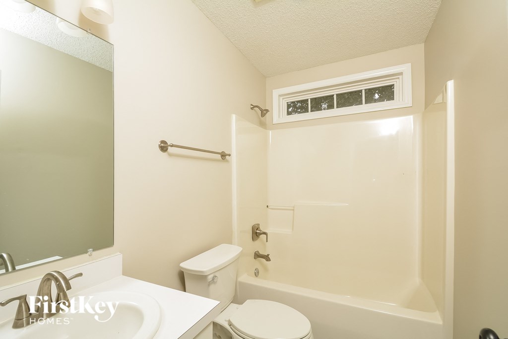 A white bathroom with a toilet, sink, and bathtub.