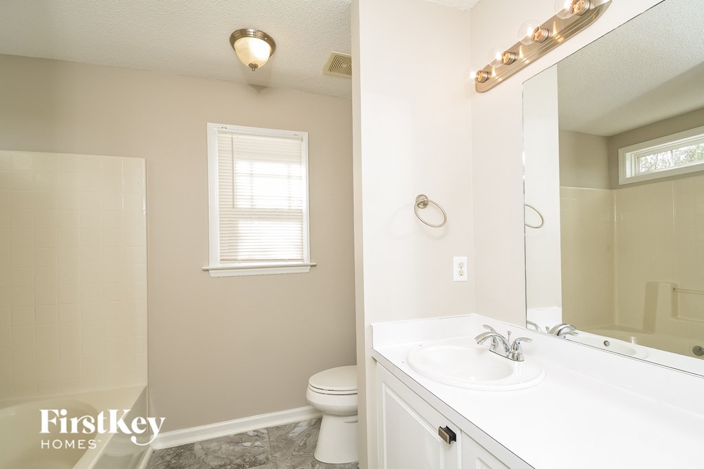 A bathroom with a white sink and a toilet.