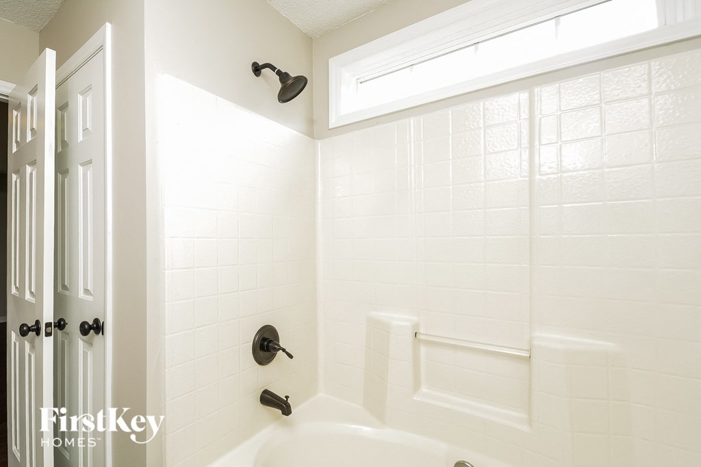 A white bathroom with a tub and a shower.