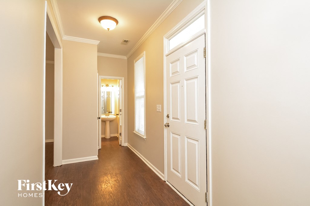 A hallway with a white door and a light on the ceiling.