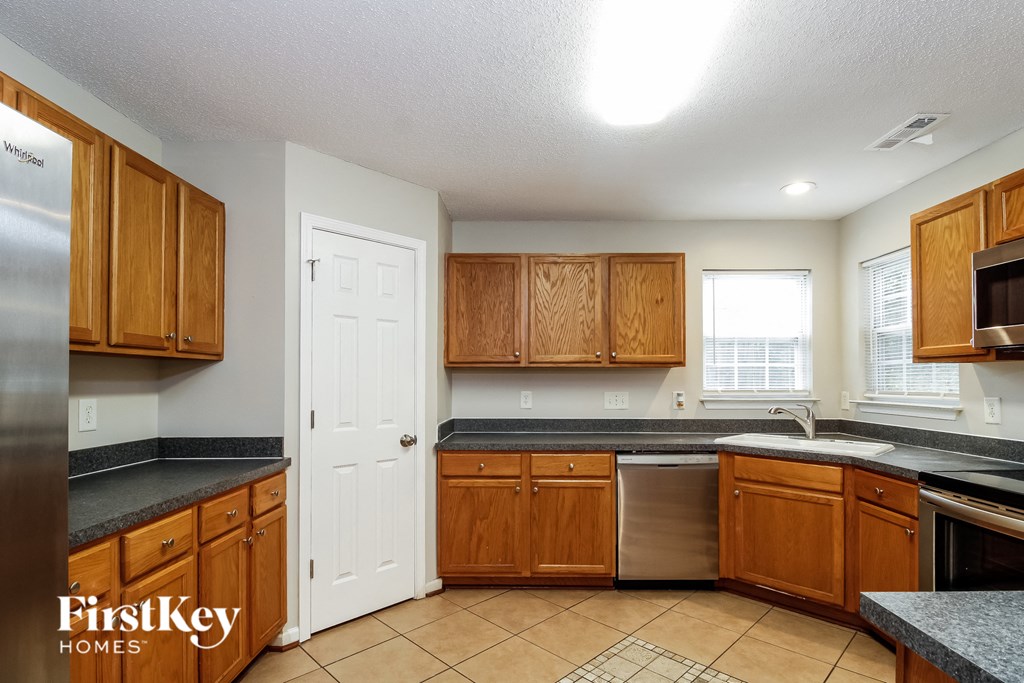 a kitchen with wooden cabinets and a sink and a refrigerator