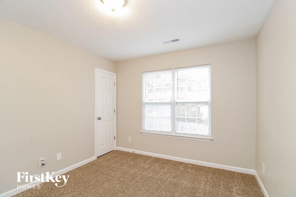 a bedroom with a large window and a white door