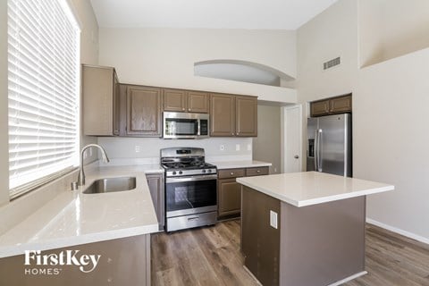 A kitchen with a stove top oven and a refrigerator.