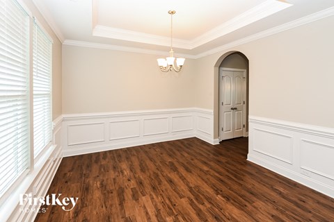 the dining room after renovation with wood flooring and an arched door