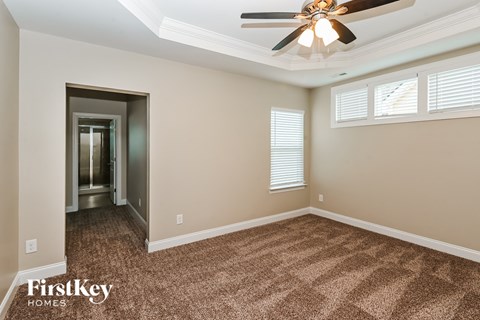 a living room with carpet and a ceiling fan