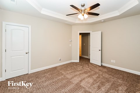 a bedroom with two doors and a ceiling fan