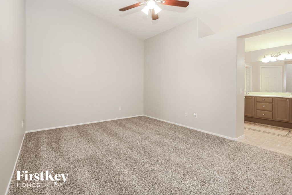 the spacious living room with white walls and carpet