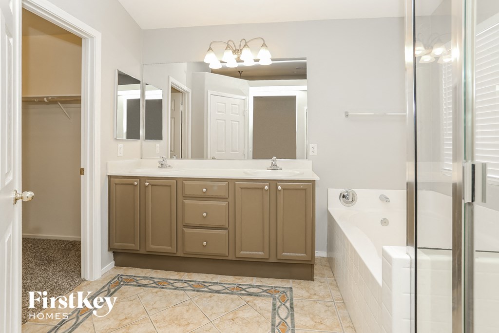 a bathroom with a tub and a sink and a mirror