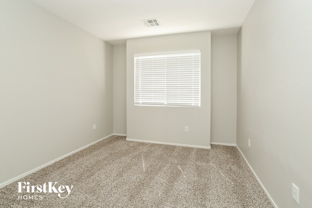 a spacious room with carpet and a window