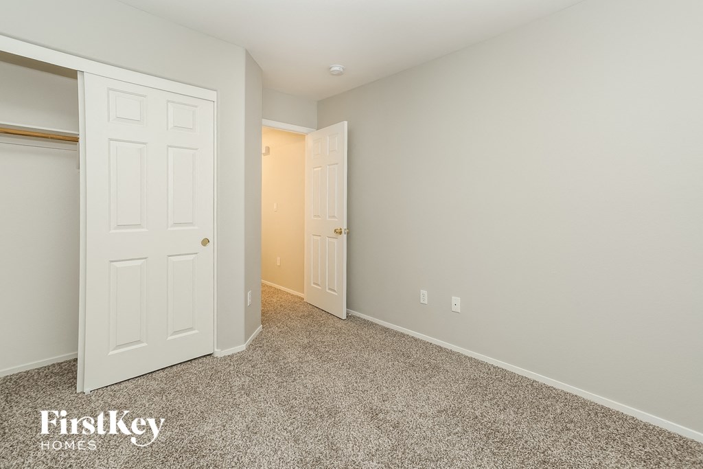 a bedroom with a closet and a door to the bathroom