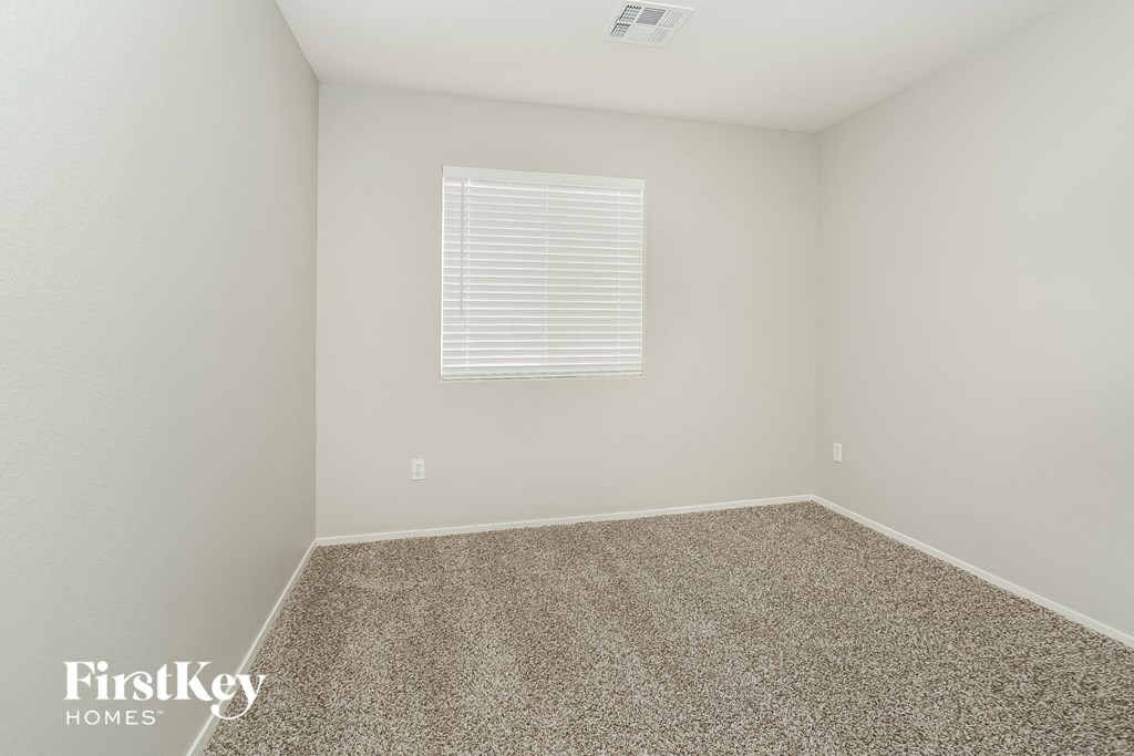 a empty room with carpet and a window