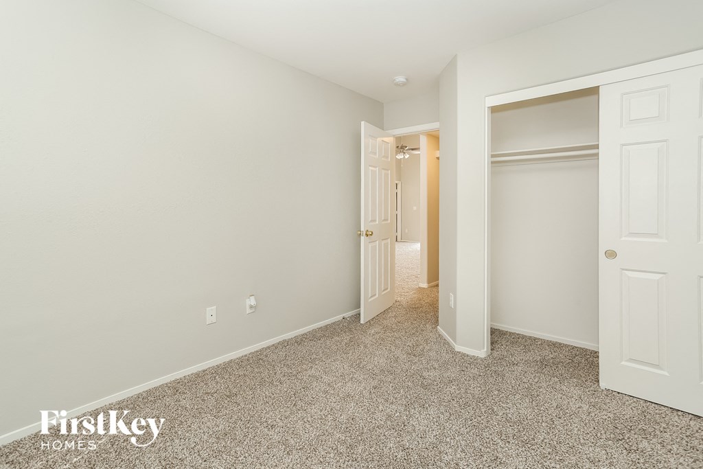 a bedroom with a closet and a door to a hallway