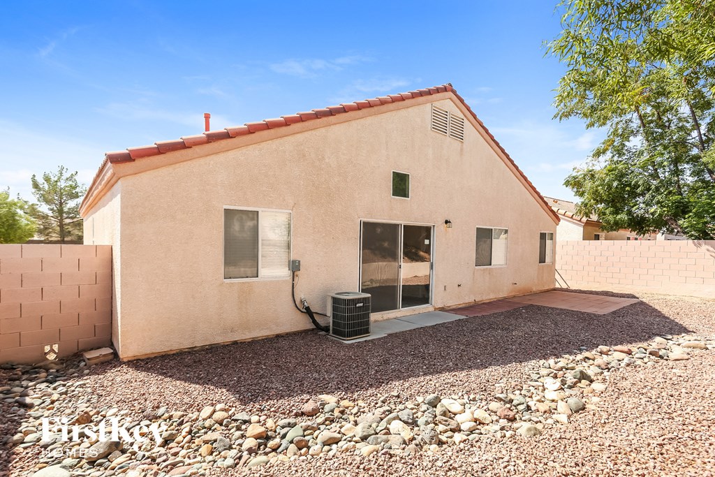 a small brick house with a yard and gravel