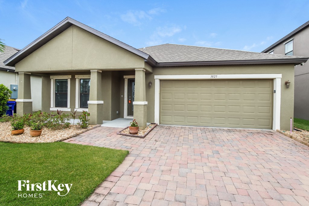 A house with a garage and a driveway in front of it.