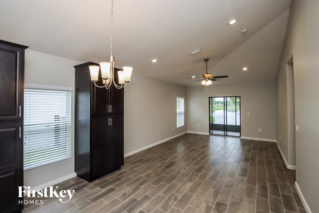 A spacious room with wooden flooring and a ceiling fan.