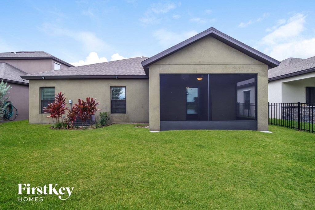 A house with a green lawn and a bicycle in the front yard.