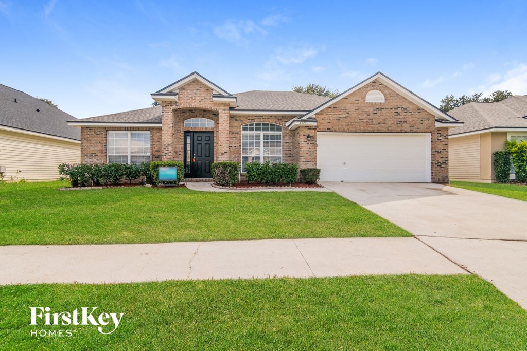 a home with a lawn and a driveway in front of it