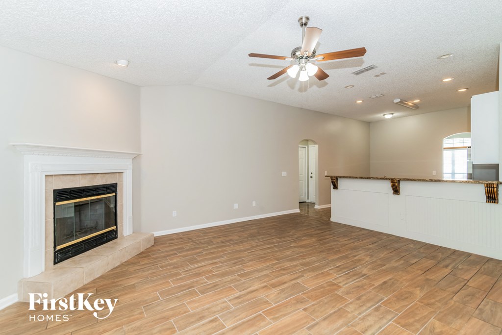 a living room with a fireplace and a ceiling fan