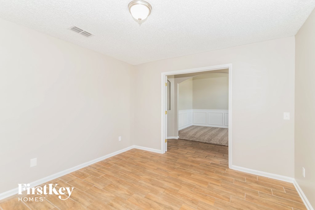 a living room with a hard wood floor and white walls