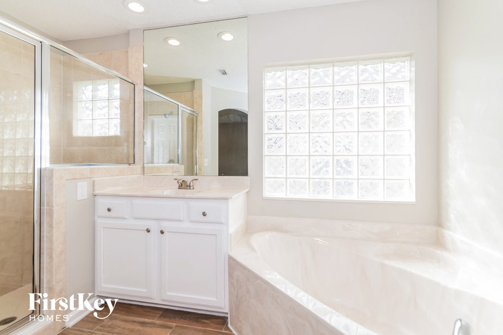 a bathroom with a tub and a sink and a mirror