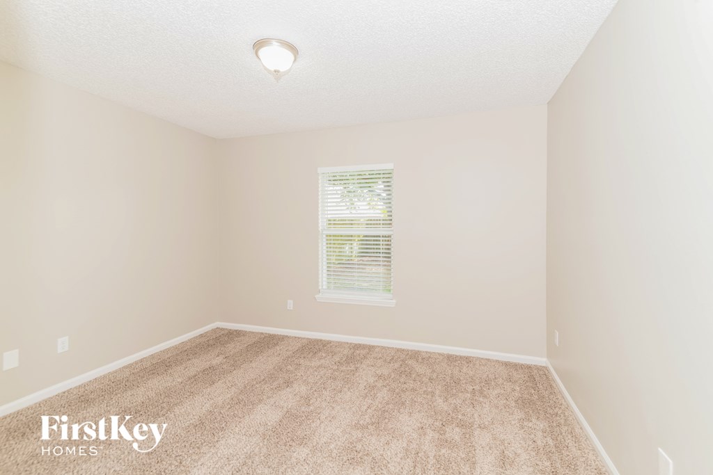 a spacious room with carpet and a window
