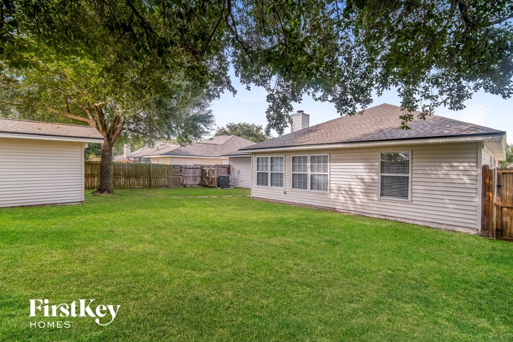 a backyard with a house and a yard with grass and trees