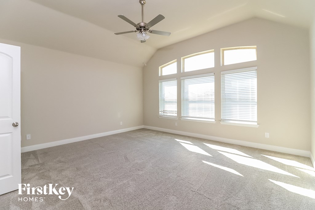 a living room with a ceiling fan and a large window
