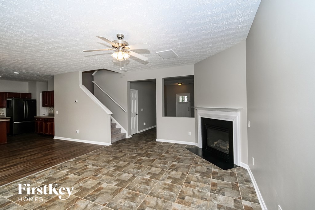 a living room with a fireplace and a ceiling fan