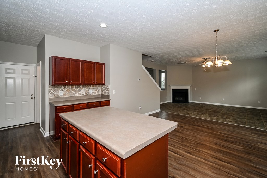 a kitchen with an island and a living room with a fireplace