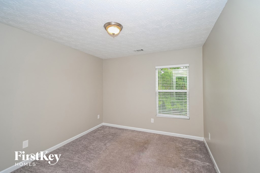 a bedroom with a carpeted floor and a window