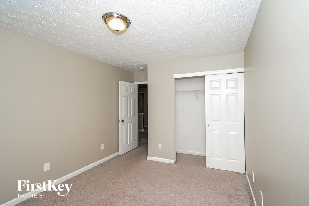 a bedroom with a closet and a door to the bathroom