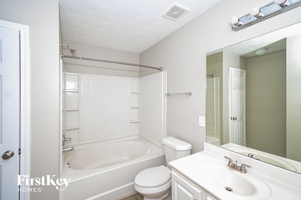 a bathroom with a tub and a sink and a mirror