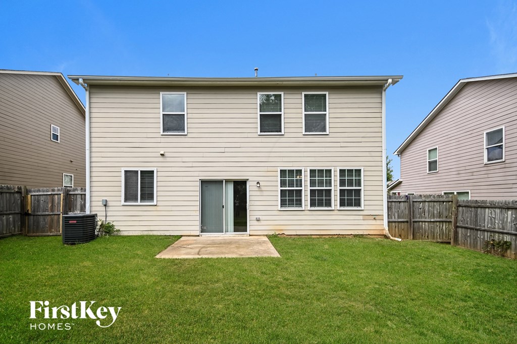 a white house with a yard and a wooden fence