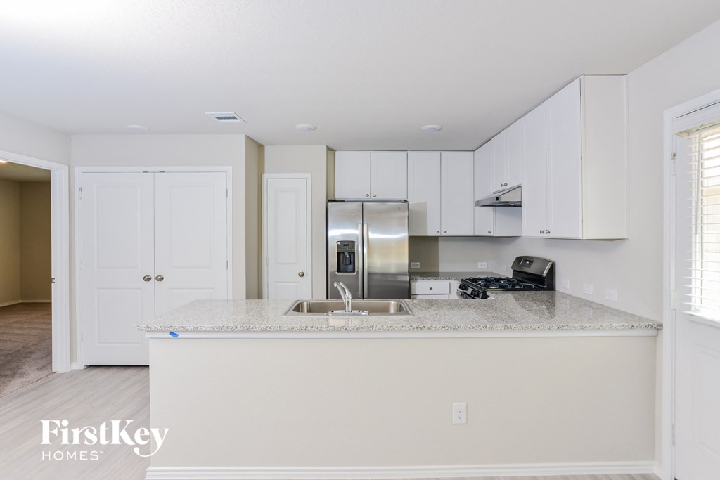 a kitchen with white cabinets and a granite counter top