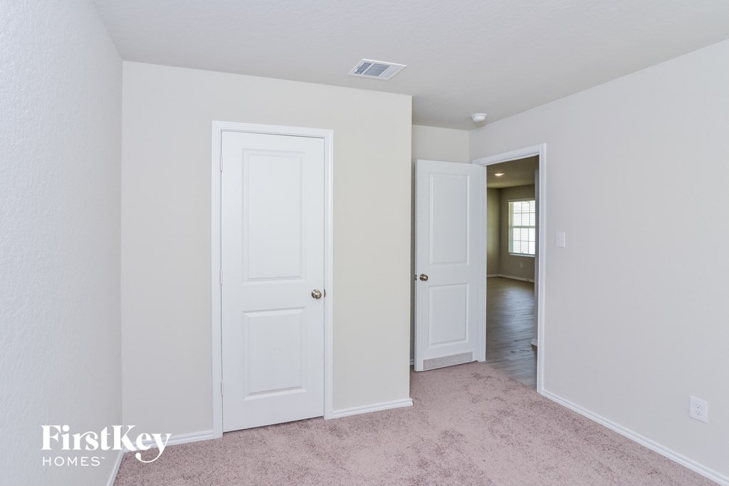 a bedroom with two closets and a door to a hallway