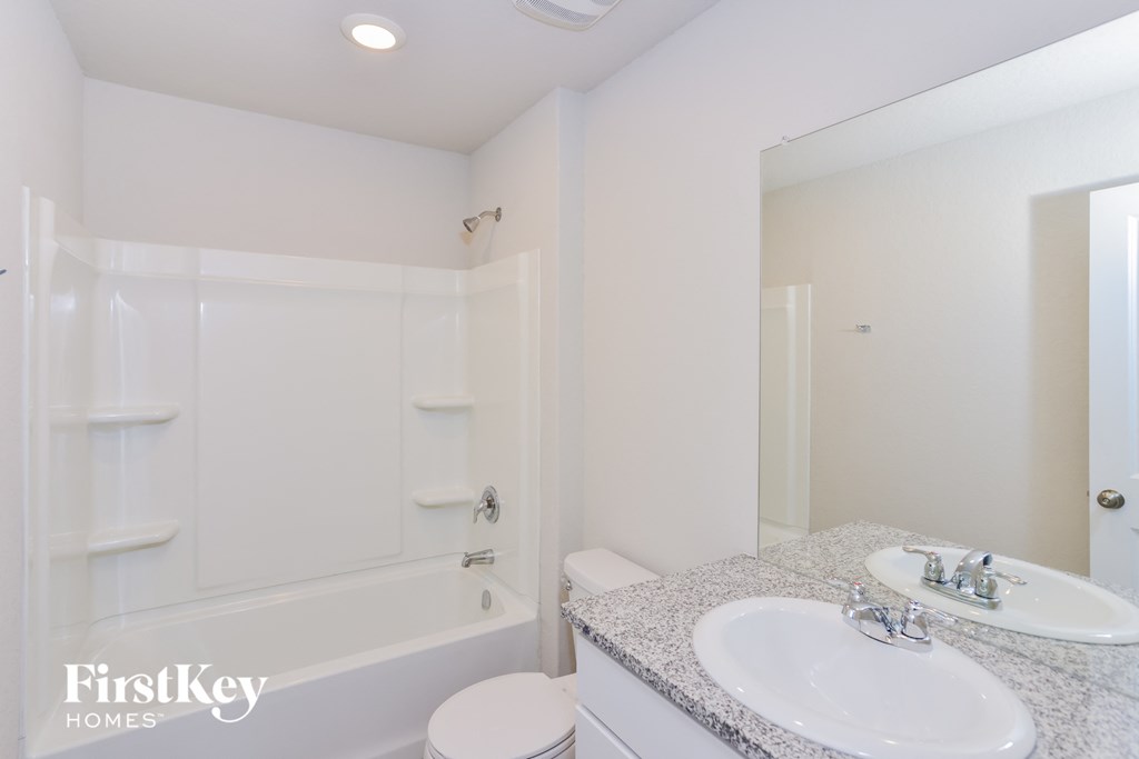 a bathroom with a sink and a bath tub and a mirror