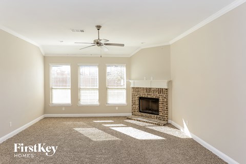 a living room with a fireplace and a ceiling fan