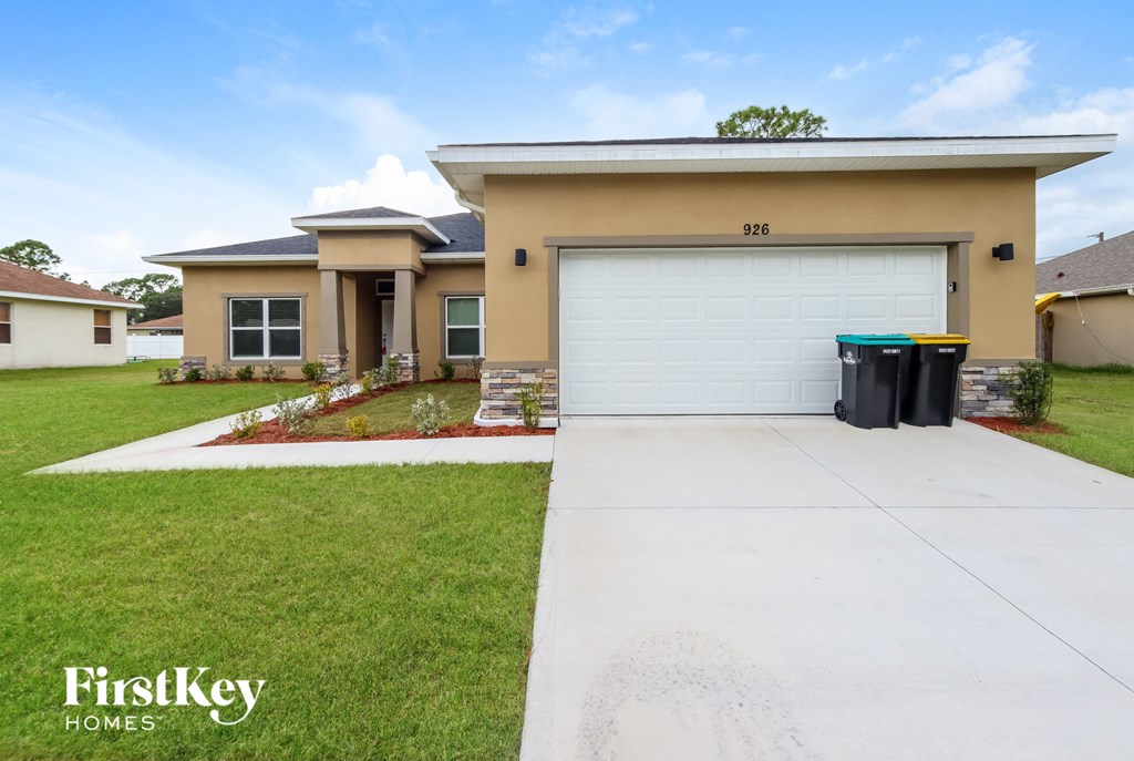 A house with a garage and a driveway in front of it.