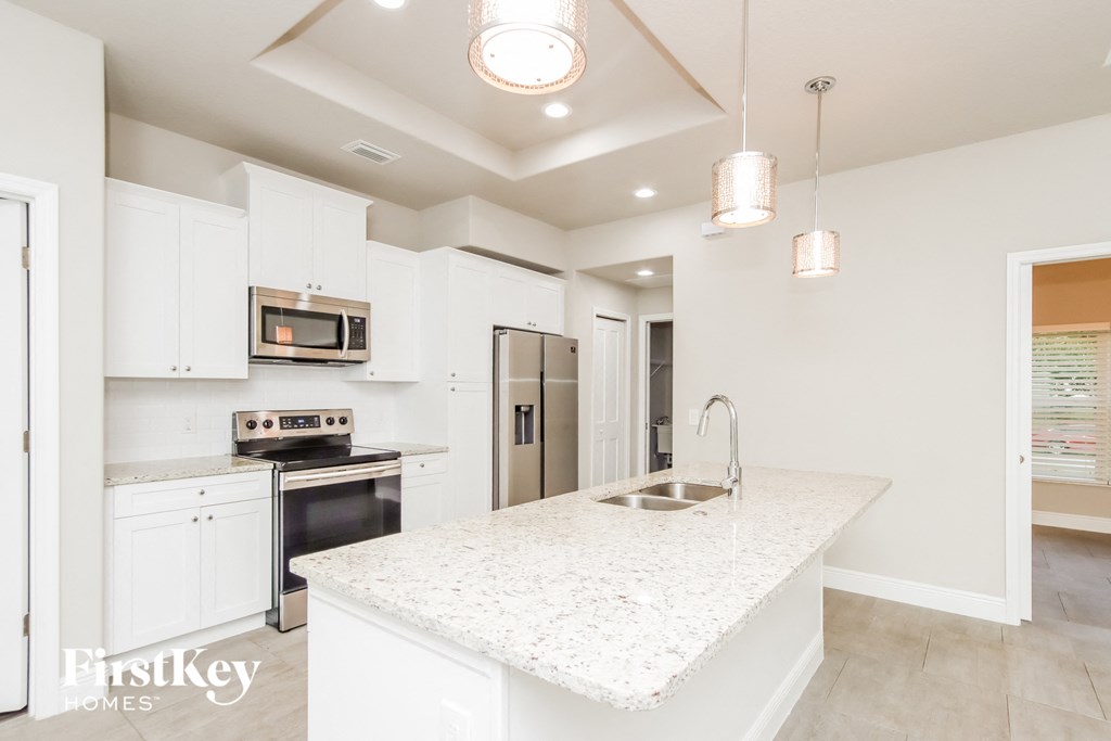 A kitchen with a white countertop and a sink.