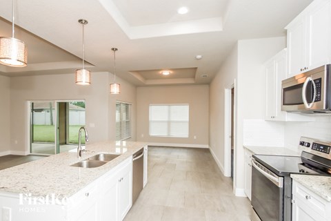 A kitchen with white cabinets and a granite countertop.