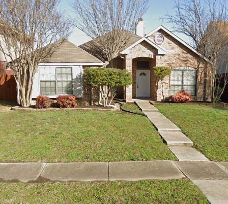 a house with a lawn and sidewalk in front of it