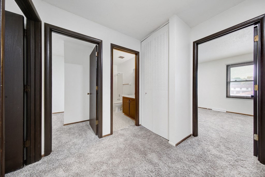 a bedroom with a door to a bathroom and a closet