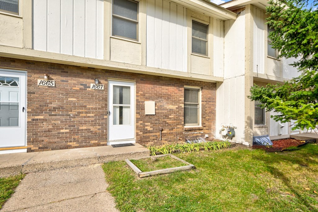 the front of an apartment building with a white door