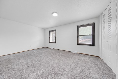 an empty living room with white walls and a window