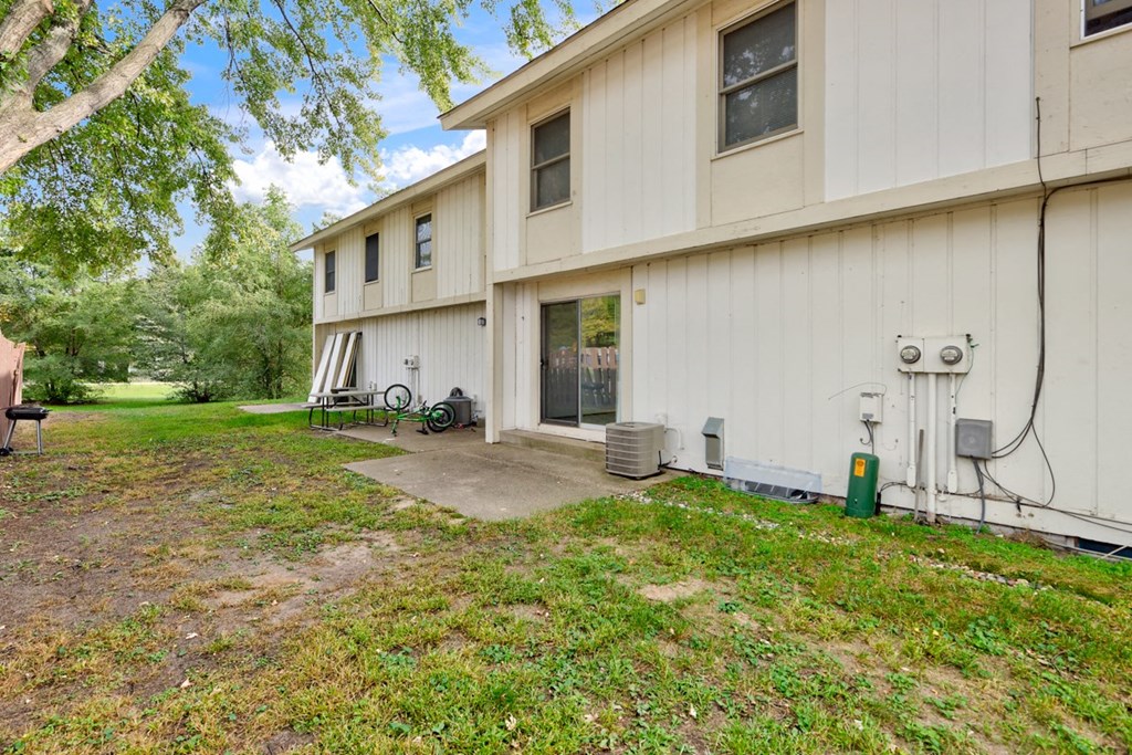 the front of a white house with a yard and trees