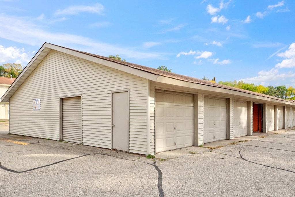 a small white building with three garage doors