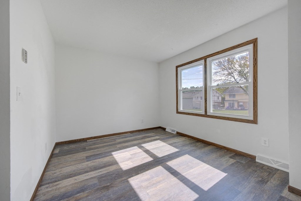 a living room with wood floors and a large window